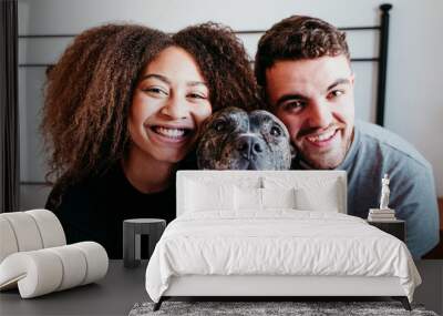 happy couple in love at home. Afro american woman, caucasian man and their pit bull dog together. Family concept Wall mural