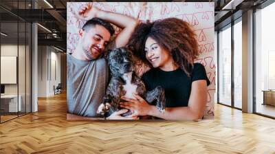 happy couple in love at home. Afro american woman, caucasian man and their pit bull dog together. Family concept Wall mural