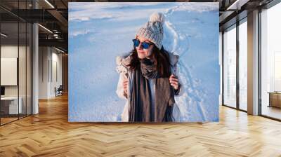 happy young woman hiking in snowy mountain wearing modern coat at sunset. winter season. nature Wall mural