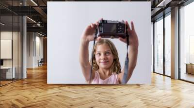 portrait of a young beautiful kid holding a vintage camera and smiling. white background. Kids indoors. Photography concept Wall mural