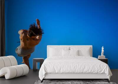 Athletic guy during a back flip salto move in the air Wall mural