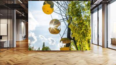 Unused ferris wheel in abandoned SSRS town Pripyat from1970s. No person. Vertical photo with a sunflare in the background and autum nature. 2019.10.08 Wall mural