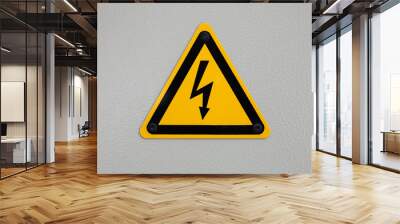 High voltage triangle warning sign mounted on gray Wall mural