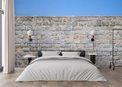 old gray stone wall and blue sky Wall mural