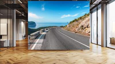 Turning mountain highway with blue sky and sea on a background Wall mural