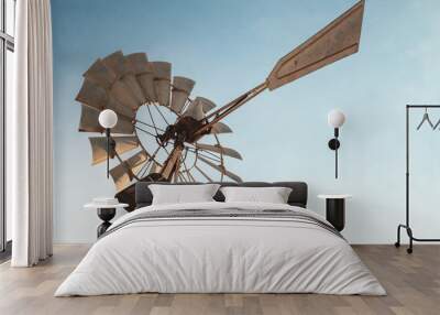 Vintage rusty wind motor under blue sky Wall mural