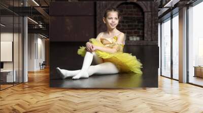 Young ballerina against black background. Wall mural