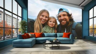 Family selfie man and woman with child outdoor mother and father with kid daughter happy smiling faces travel lifestyle together Wall mural