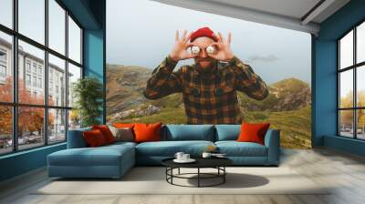 Joyful man having fun outdoor travel vacation lifestyle comic positive emotions guy holding sea urchins shells like big eyeballs Wall mural