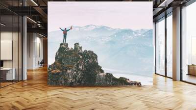 Man climbing on mountain top adventure travel outdoor extreme active lifestyle vacation tour hiking in Norway success raised hands Husfjellet peak Wall mural