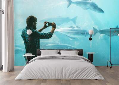 Man taking photo using smartphone of fish in big aquarium Travel Lifestyle concept modern technology Wall mural