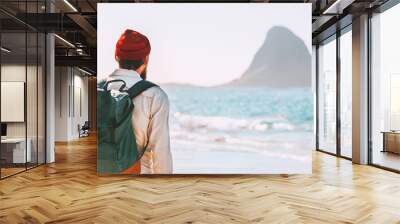 Summer vacations young man with backpack outdoor walking on ocean beach traveling lifestyle adventure enjoying landscape active trip exploring Norway Wall mural