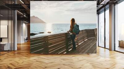 Traveler woman contemplating standing alone on bridge travel lifestyle vacations outdoor solitude emotions sunset sea view Wall mural