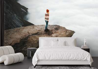 Woman explorer walking on Trolltunga rocky cliff in Norway mountains Travel Lifestyle adventure concept extreme vacations outdoor above clouds Wall mural