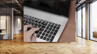 Close up of business man working on laptop computer on wooden de Wall mural