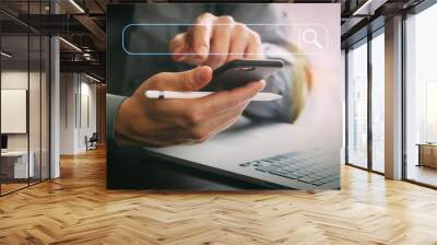 close up of businessman working with mobile phone and stylus pen and laptop computer on wooden desk in modern office Wall mural