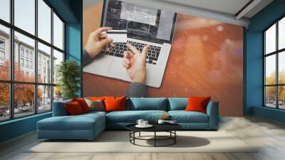 top view of hands using laptop and holding credit card with digi Wall mural