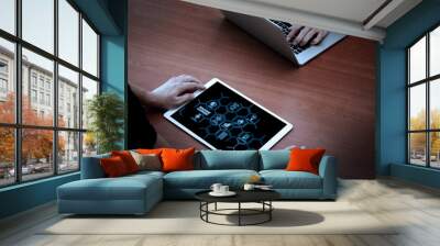 top view of two colleagues discussing data with new modern computer laptop and pro digital tablet on wooden desk as concept Wall mural