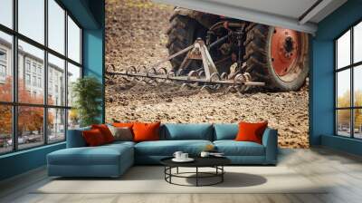 plow tractor plows the land for planting agricultural plants. the farmer cultivates the land in the spring for sowing seeds. iron plow of the mechanized machine Wall mural