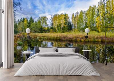 October, autumn forest is reflected in the blue water of the river Wall mural