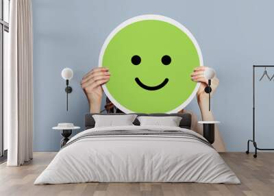 Girl holding a paper poster with a happy cheerful smiley Wall mural