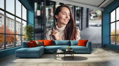 Portrait of a happy young woman against the background of an office building Wall mural