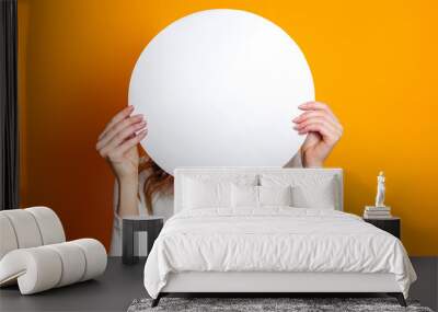 Student hold blank white speech balloon isolated on an orange studio background. copy space Wall mural