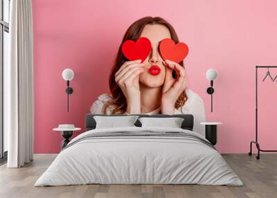 The girl closes her eyes with paper hearts and sends an air kiss. Valentine's Day. Emotion girl in love Wall mural