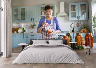 Woman in the kitchen canning vegetables Wall mural