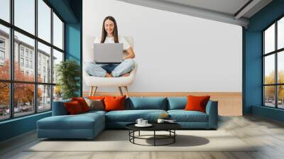 woman holding laptop computer while sitting on a chair web banner Wall mural