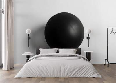 A black sphere centered on a white surface with soft shadow. Wall mural