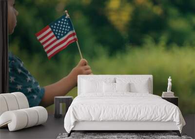 A close-up of a child's hand holding a small American flag, symbolizing patriotism and pride. 4th of July, american independence day, happy independence day of america , memorial day concept Wall mural