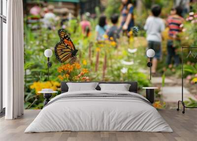 A monarch butterfly on a flower in a garden, with children observing in the background. a butterfly garden in an urban school yard, with children observing the wildlife Wall mural