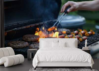 A person grilling burgers and skewers over a fiery barbecue grill, with visible flames and smoke, in an outdoor setting. 4th of July, american independence day, memorial day concept Wall mural