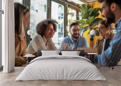 Cheerful, diverse business team engaging in discussion in a sunny office. Wall mural