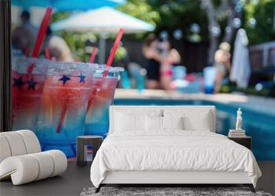 Festive beverages served at a pool party, featuring red, white, and blue layered drinks adorned with star-shaped decorations and straws. The drinks are set against a backdrop of a sparkling pool. Wall mural