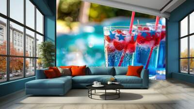 Festive beverages served at a pool party, featuring red, white, and blue layered drinks adorned with star-shaped decorations and straws. The drinks are set against a backdrop of a sparkling pool. Wall mural