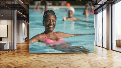 Smiling african american senior woman doing aqua fitness. Happy mature healthy woman taking fitness classes in aqua aerobics. Healthy old woman doing aqua gym Wall mural