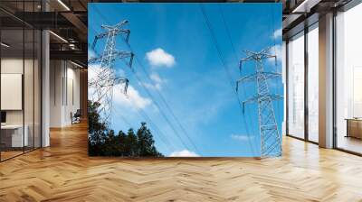 A high-voltage electricity pylons against blue sky with clouds at sunny day. High-voltage power transmission towers. Power engineering. Wall mural