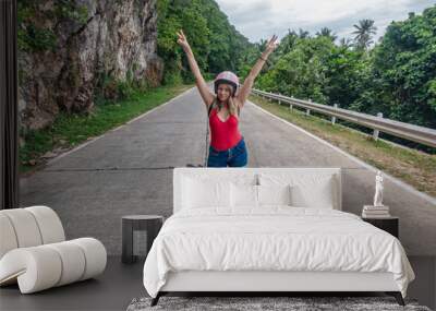 Young woman posing on a scenic mountain road in tropical setting during daytime Wall mural