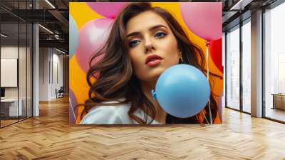 Beauty portrait of a charming young woman on a bright multi-colored background with air balloons. Wall mural