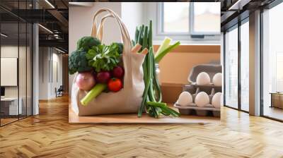 Fabric bag, shopper with fresh vegetables and herbs on a wooden tabletop in a light kitchen. Ecological and healthy food, life without garbage. Wall mural