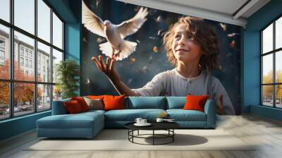 Boy with beautiful curly hair releases a white dove from his hands against the backdrop of a fairytale forest and flying butterflies and leaves. Wall mural