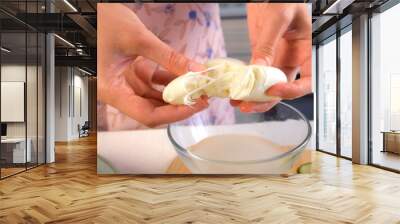 Woman hands rips large piece of mozzarella cheese into parts on kitchen at home. Cooking Italian food, dish. Tasty delicious meal. Fresh ingredient, preparing delicacy. Wall mural