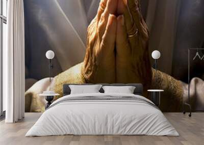 Women's hands are folded in prayer in the church's concept of faith, religion, love and forgiveness. Wall mural