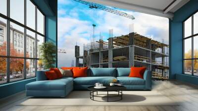 Close-up view of process of building new house. Concrete top floor of new multi-story building against cloudy sky. Modern concrete structure, building under construction. Abstract background Wall mural