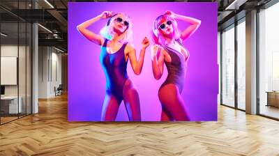 Fashion. Two DJ girl in Colorful neon light enjoy music, friends. Party disco 80s 90s neon nightclub vibes. Model woman in disco bodysuit, makeup dance. Creative art neon light Wall mural