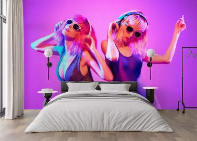 Fashion. Two DJ girl with Dyed Hair, party makeup in Colorful neon light enjoy music, friends. Disco 80s 90s vibes. Model woman in fashionable bodysuit, make up dancing. Art uv neon banner Wall mural