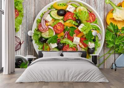 Greek salad with cucumeber, olives, feta cheese, cherry tomatoes, bell pepper and lettuce. Summer diet salad concept. Tasty greek salad in bowl on wood, top view, banner Wall mural