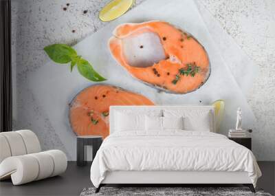 Red fish steaks marinated for cooking with ingredients are on parchment. Top view, light background Wall mural